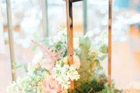 a lovely rustic wedding centerpiece of a tree slice, moss, greenery and neutral blooms is amazing for spring