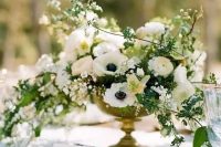 a lush and cascading white wedding centerpiece with various blooms and greenery
