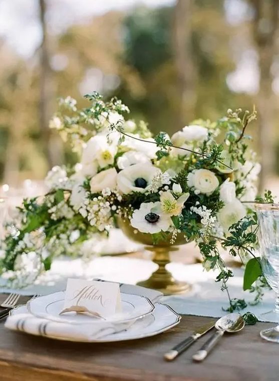 a lush and cascading white wedding centerpiece with various blooms and greenery