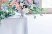 a lush pastel wedding centerpiece of dusty pink, white and lilac hydrangeas and eucalyptus is a gorgeous idea