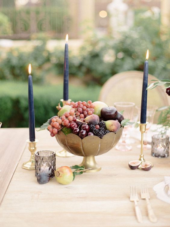 a metallic bowl with fresh fruit and black candles are a gorgeous combo for a decadent fall wedding