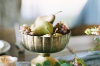 a metallic bowl with grapes and pears is a very affordable and lovely wedding centerpiece you can make