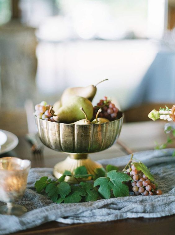a metallic bowl with grapes and pears is a very affordable and lovely wedding centerpiece you can make