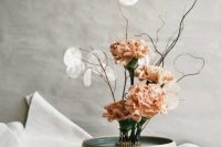 a modern ikeabana-style wedding centerpiece of a bowl with blush carnations and lunaria is amazing