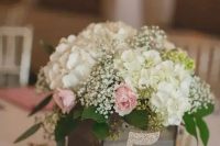 a reclaimed wooden box with baby’s breath, hydrangeas and roses, a glitter table number for a rustic wedding centerpiece
