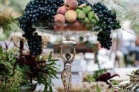 a refined tall bowl wedding centerpiece with delicious fruit is perfect for a fall wedding