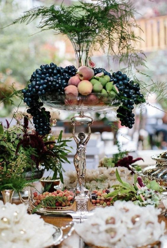 a refined tall bowl wedding centerpiece with delicious fruit is perfect for a fall wedding