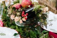a silver bowl with wildflowers, apples and aubergines is a cool idea for a fall harvest wedding