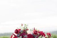 a super bold wedding centerpiece with burgundy and fuchsia blooms, peachy flowers, thistles and greenery