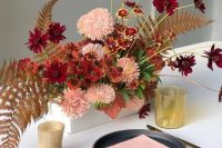 a super bright box wedding centerpiece with pink, rust and burgundy blooms, dried fern leaves looks spectacular