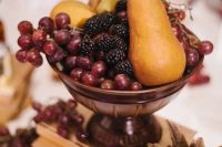 a vintage wedding centerpiece of a book stack and a bowl with fresh fruit will be great for a fall vintage wedding