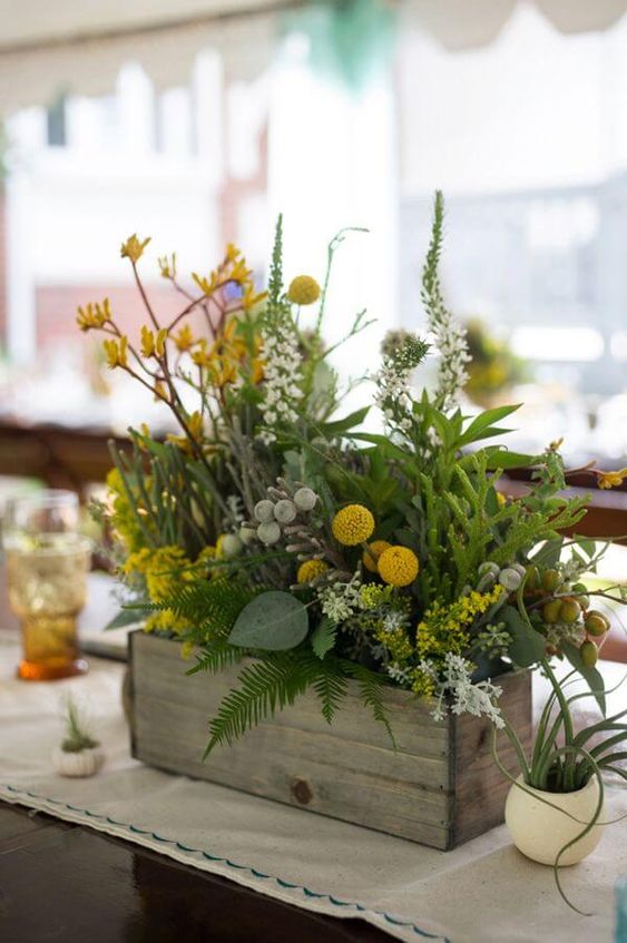 a woodland wedding centerpiece of a box with greenery, wildflowers and billy balls is a lovely idea you can realize yourself
