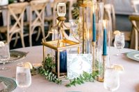 candle lanterns with navy candles and greenery are adorable, and I love the color combo of gold and navy