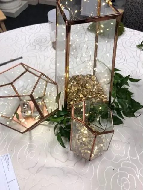 copper terrariums with LEDs and greenery around for a Christmas centerpiece, such decor always creates a mood