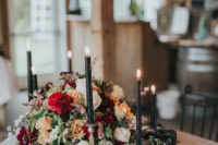02 The wedding centerpiece was made with bold lush flowers, with red, yellow and orange blooms and black candles and candle holders looked matching