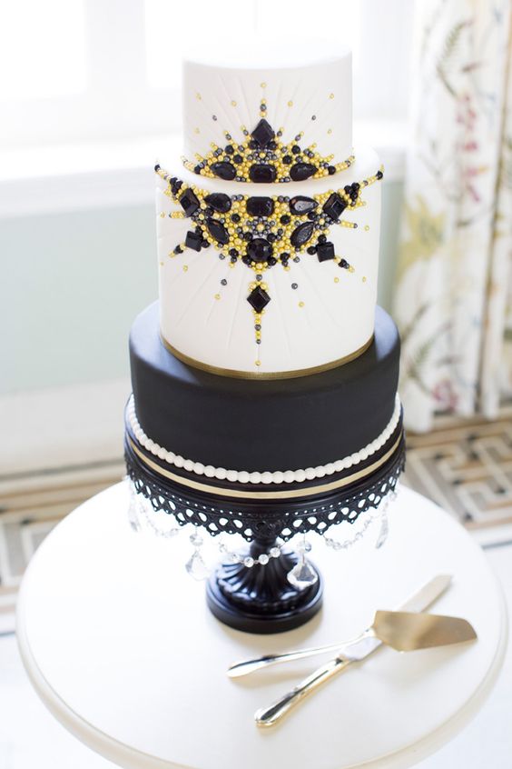 a black and white wedding cake with pearls, yellow and black beads and rhinestones