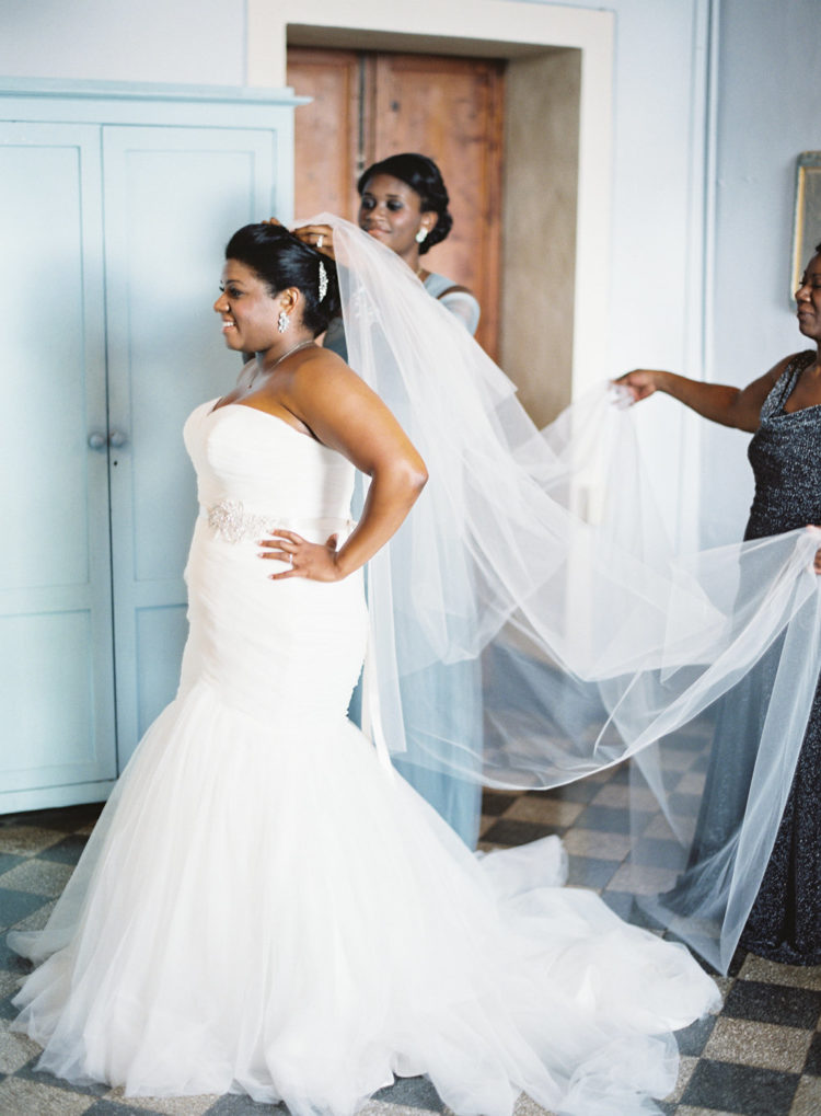 The bride chose a strapless mermaid wedding gown with a train, statement earrings and a veil