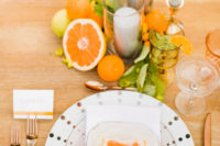 03 The tablescape was done with candles and different types of citrus, polka dot plates, quartz slice place cards