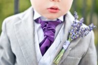 03 a ring bearer dressed into a light grey suit, with a purple tie and a lavender boutonniere