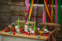 04 The wedding table was decorated with a Peruvian-inspired table runner, pompoms, a bold bottle as a vase and cacti