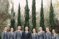 04 groomsmen dressed in grey suits with black ties and the groom in black to stand out