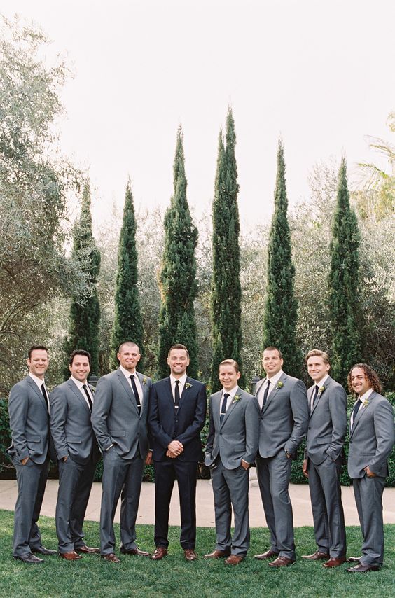 groomsmen dressed in grey suits with black ties and the groom in black to stand out