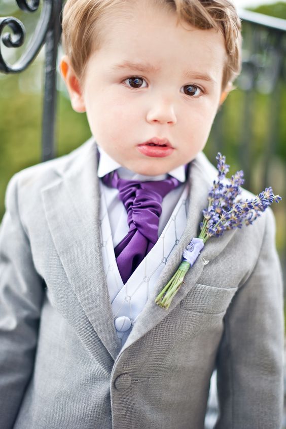 a grey suit with a neutral waistcoat and a purple tie