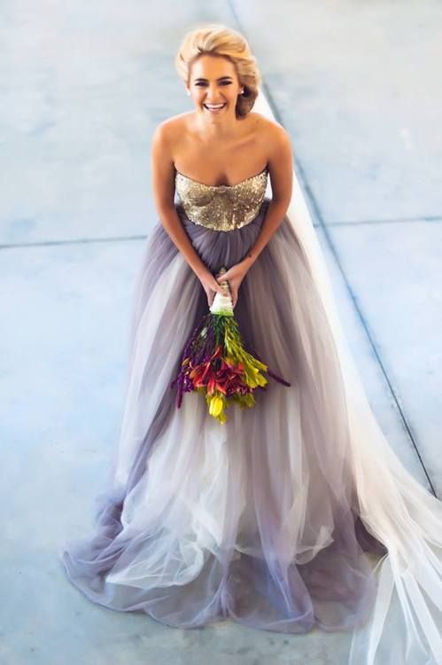a wedding dress with a gold sequin bodice and a layered cream and purple wedding skirt