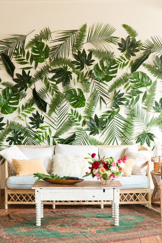 a wedding lounge with a tropical leaf wall - real leaves are attached to the wall
