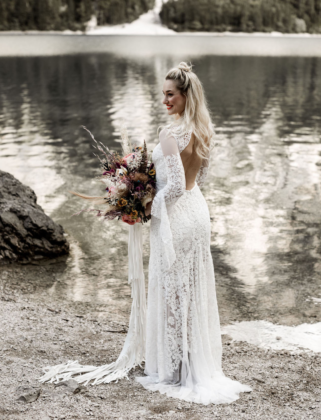 The boho lace wedding dress with wide sleeves and an open back looked very cool and the bouquet had ribbon that reminded of the dress