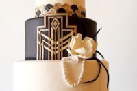 07 a black, white and gold wedding cake with geo decor, buttons, edible pearls, a sugar flower and a rhinestone monogram