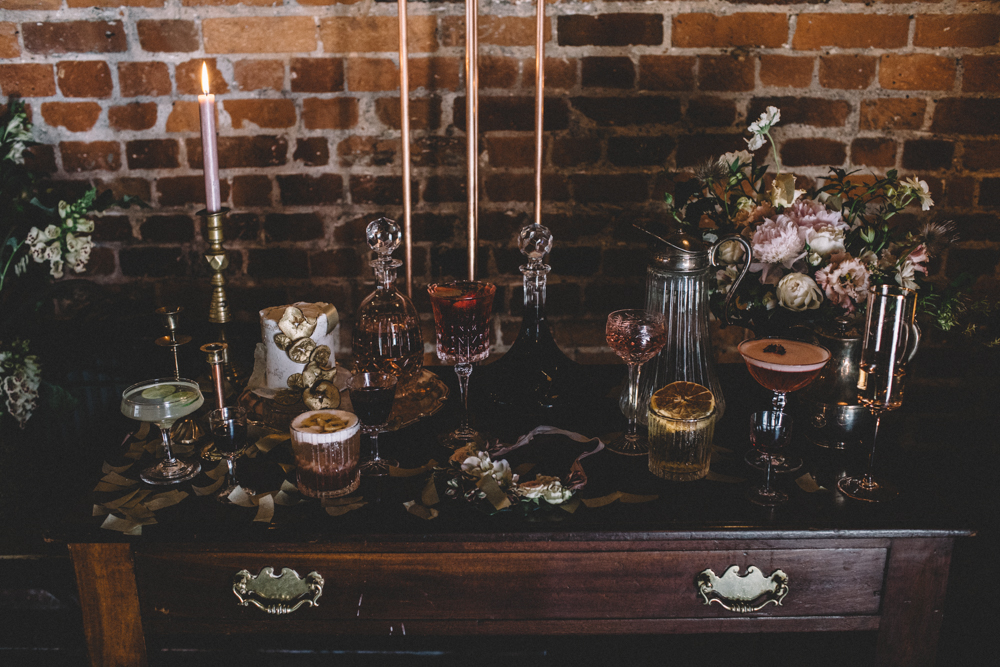 A refined cocktail bar with dusty pink candles and desserts