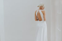08 a modern wedding dress with a halter neckline and a cutout back on wide straps
