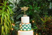 11 The wedding cake was white, emerald and gold, with a pattern and air plants and a gold topper
