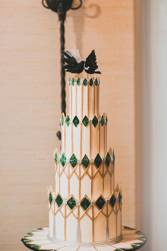 a unique wedding cake with spiky emeralds, gold geo prints and black bird toppers