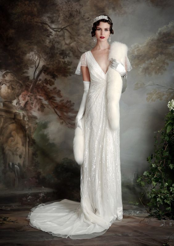sparkling wedding dress with a deep V-neckline and cap sleeves, a small train and a faux fur shawl