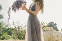 13 a grey lavender wedding dress with a plunging neckline and a lavender floral arrangement