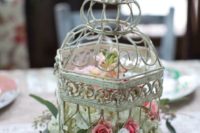13 a shabby chic bird cage with white, pink and blush florals