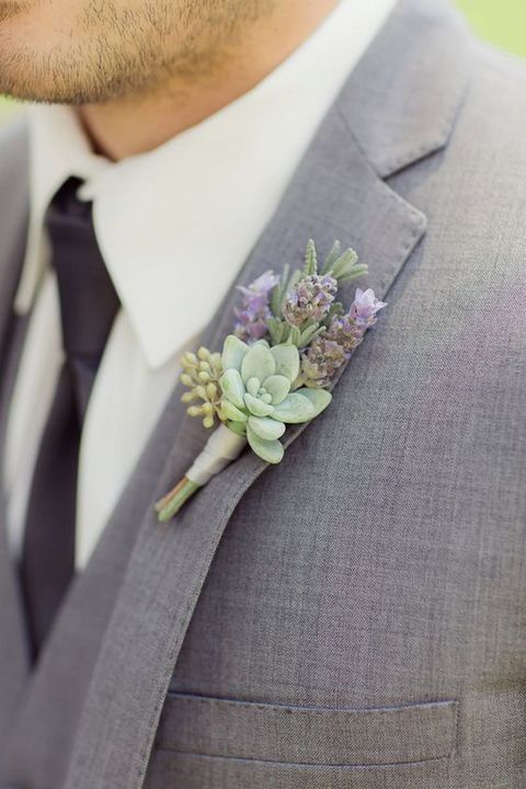 a grey wedding suit with a succulent and lavender boutonniere and a black tie looks wow