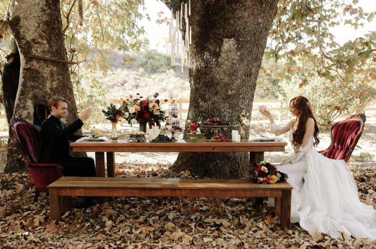 a rustic tablescape with burgundy velvet chairs right in the forest