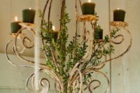 14 a vintage chandelier decorated with greenery and with dark green candles