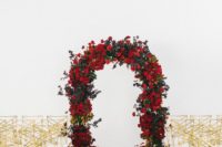 16 a lush red rose and greenery wedding arch with gold and white chairs make up a refined ceremony space
