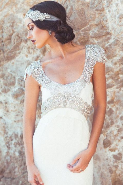 a deep scoop neckline wedding gown with a heavily embellished neckline and waistline, cap sleeves