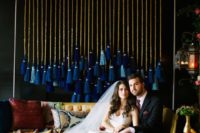 a wedding backdrop with large tassels in the shades of blue for a wedding reception
