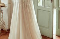 19 cap sleeve wedding dress with a lace applique illusion back and a flowy skirt