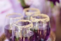 19 purple signature wedding drinks in gold rim glasses and on a gold tray