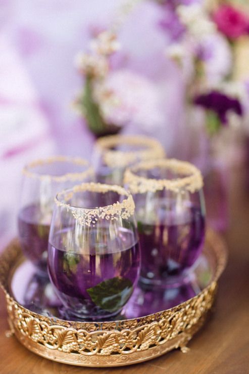 purple signature wedding drinks in gold rim glasses and on a gold tray
