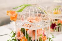 20 a white cage with lush orange, peachy and burgundy blooms for a bold wedding