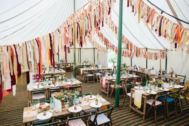 colorful tassel garlands over the reception for a cheerful boho chic wedding