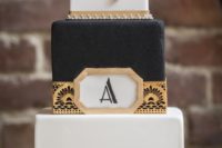 22 a gorgeous black and white square cake with gold geo decor, vintage brooches and beading and feathers